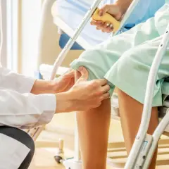 Medico esegue il Lachman test su un paziente in ospedale, valutando la stabilità del ginocchio.