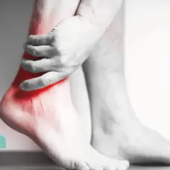 Dolore ai tendini caviglia interna evidenziato in rosso. Un uomo si tiene la caviglia, indicando un possibile problema.