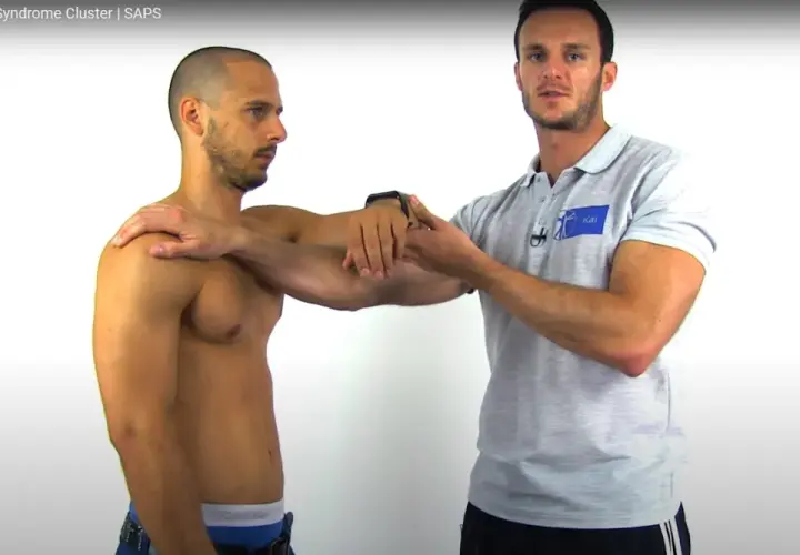 Un fisioterapista esegue un impingement test su un paziente, valutando la spalla.