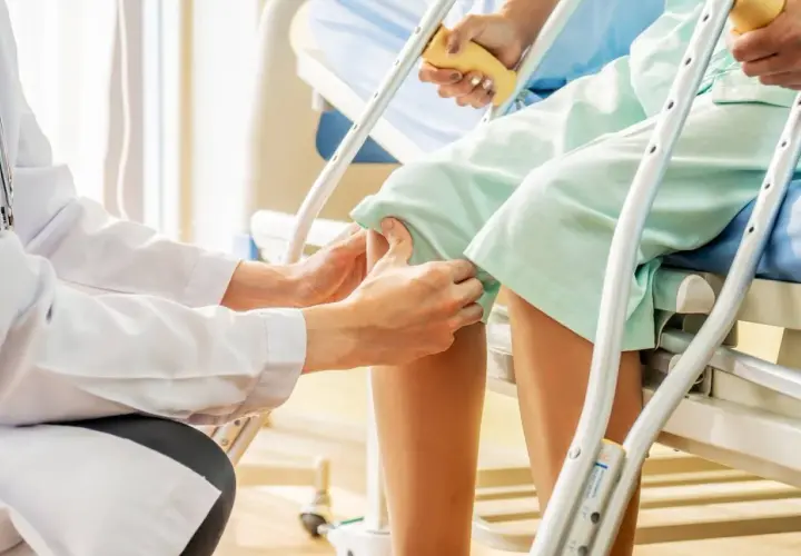 Medico esegue il Lachman test su un paziente in ospedale, valutando la stabilità del ginocchio.