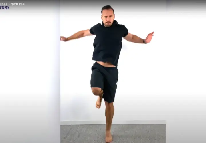Uomo in nero esegue un hop test, saltando su una gamba sola.