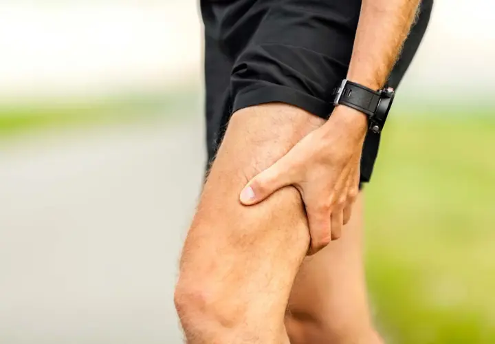 Atleta con mano sulla coscia, indicando una possibile lesione muscolare.