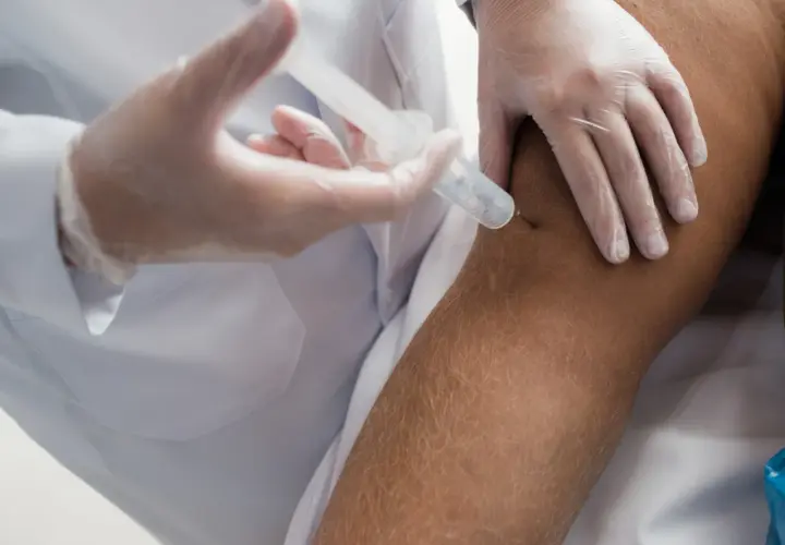 Iniezione al ginocchio per alleviare i dolori muscolari dopo cortisone.