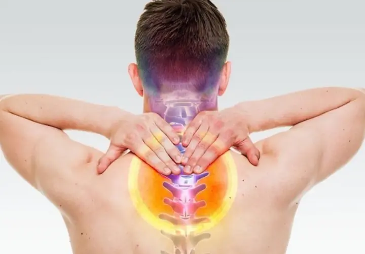 Uomo con mani sul collo e schiena, evidenziando dolore e possibili conseguenze di frattura vertebra cervicale.