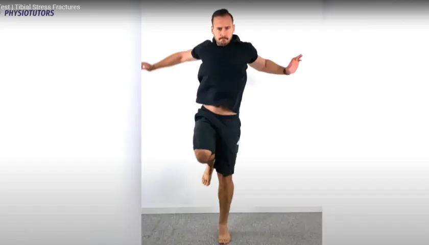 Uomo in nero esegue un hop test, saltando su una gamba sola.