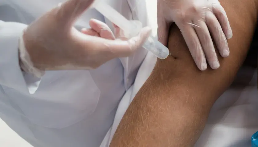 Iniezione al ginocchio per alleviare i dolori muscolari dopo cortisone.