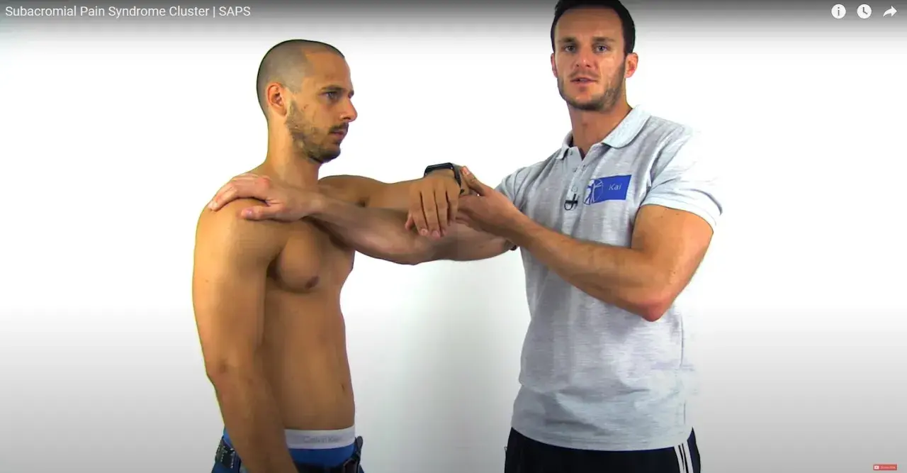 Un fisioterapista esegue un impingement test su un paziente, valutando la spalla.
