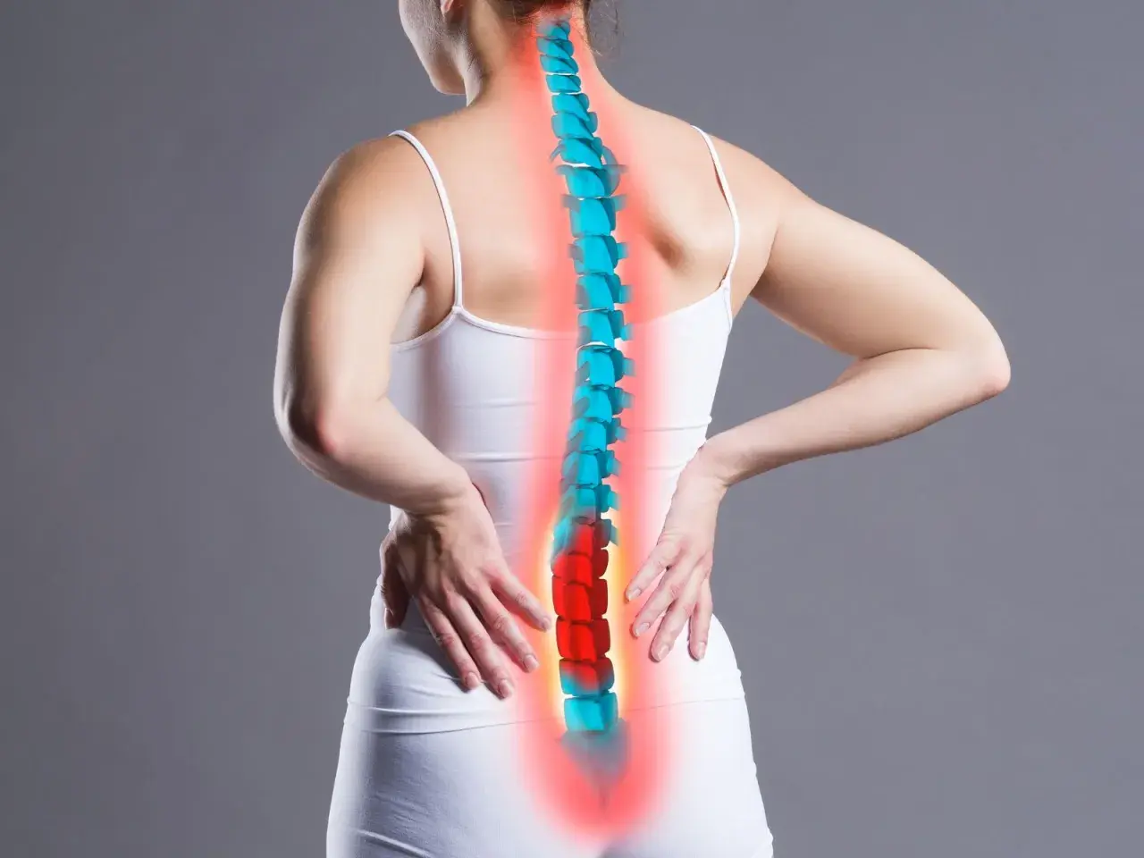 Donna con mani sulla schiena, colonna vertebrale evidenziata in rosso e blu. Il dolore lombare, il rachialgia significato, è rappresentato dal colore rosso.